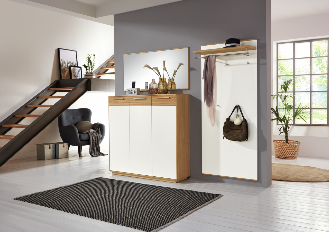 VOSS Dielenschrank LOVENO Moderne Garderobeneinrichtung mit Schuhschrank, Spiegel und Garderobenpaneel in einem stilvollen Raum mit Treppe, aus der Perspektive des Eingangsbereichs betrachtet.