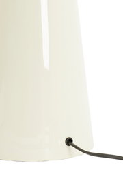 Nahaufnahme eines weißen Lampenfußes mit schwarzem Kabel, seitliche Perspektive