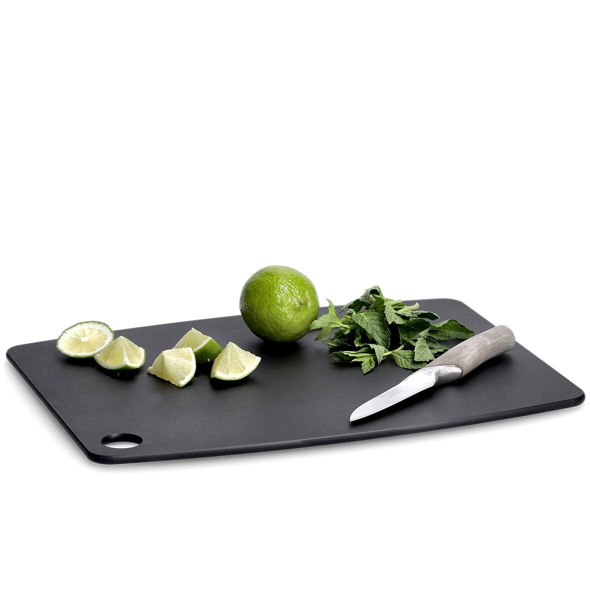 Schwarzes Schneidebrett aus Holzfaserlaminat mit Limetten, Kräutern und einem Messer, seitliche Perspektive