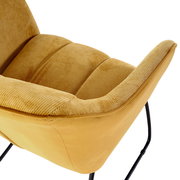 Nahaufnahme eines gelben Armlehnstuhls mit weichem Stoffbezug und schwarzen Metallbeinen, seitliche Perspektive