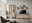 Moderne Wandkombination aus Holz in einem Wohnzimmer, bestehend aus einem hohen Schrank mit Glastüren, einem TV-Schrank und einem Wandregal, seitliche Perspektive.