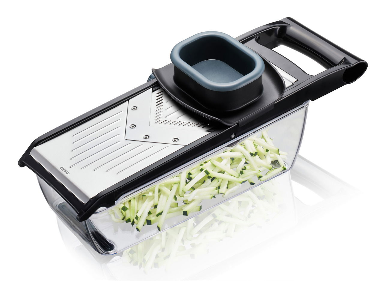 V-Hobel Julienne mit schwarzem Griff und transparentem Auffangbehälter, gefüllt mit geschnittenem Gemüse, aus seitlicher Perspektive.