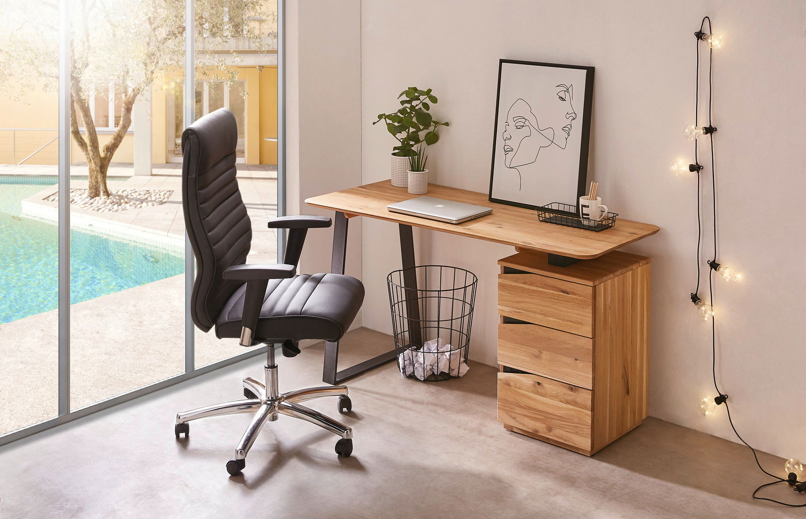 Moderner Chefsessel in schwarzem Leder, seitliche Perspektive, neben einem Schreibtisch mit Laptop und Dekorationen, mit Blick auf einen Pool im Hintergrund.