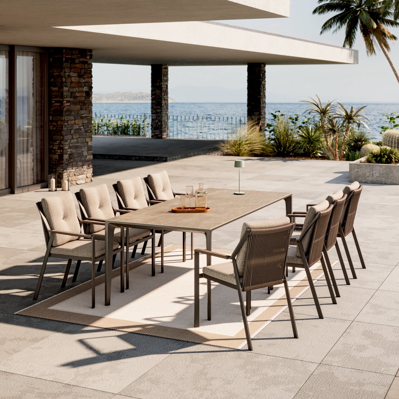 Moderner Gartensessel in einer stilvollen Outdoor-Essgruppe mit Meerblick, seitliche Perspektive.