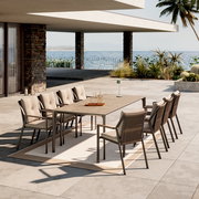 Moderner Gartensessel in einer stilvollen Outdoor-Essgruppe mit Meerblick, seitliche Perspektive.