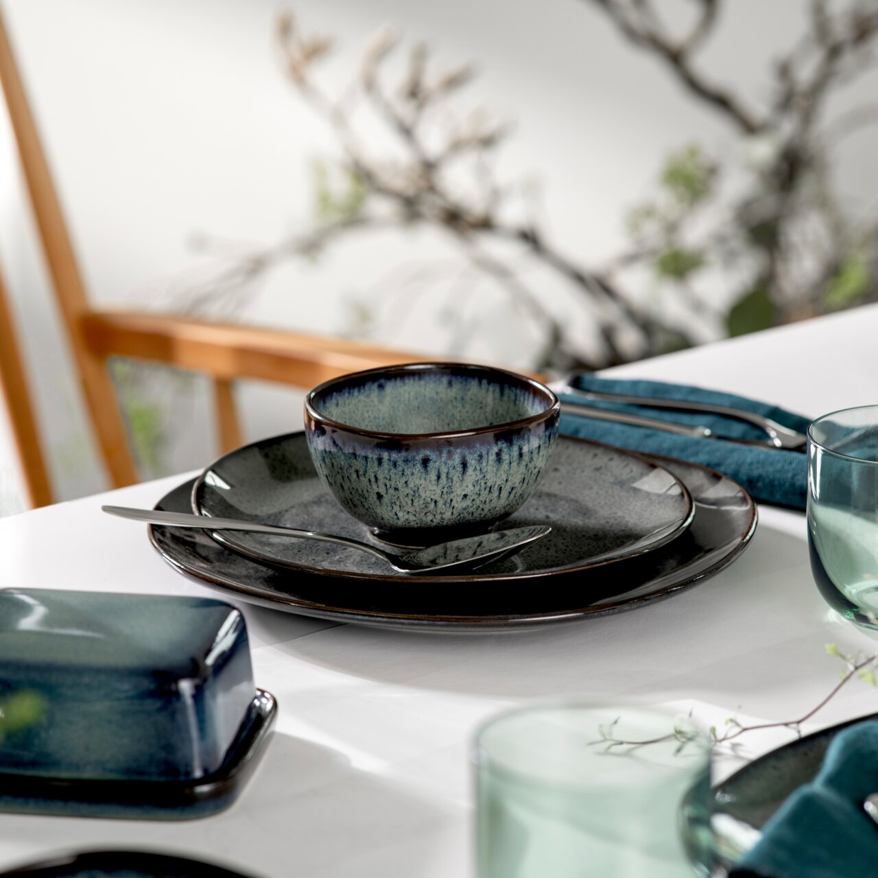 Like by Villeroy & Boch Bowl LAVE GRIS Dessertschale Lave 210ml grau, stilvoll auf einem gedeckten Tisch mit Besteck und Serviette, seitliche Perspektive