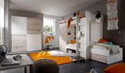 Modernes Hochbett in einem stilvollen Kinderzimmer mit grauen Wänden, einem Schreibtisch und einem orangefarbenen Teppich. Perspektive: seitliche Ansicht des Bettes.