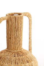Nahaufnahme einer handgefertigten Vase aus geflochtenem Naturmaterial mit zwei Griffen, seitliche Perspektive
