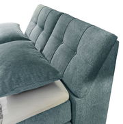 Nahaufnahme eines Boxspringbetts mit gepolstertem Kopfteil in blauer Stoffoptik, seitliche Perspektive