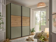 Moderne slaapkamer met grote kast met schuifdeuren in olijfgroen en houtlook, zwarte kozijnen, schuin aanzicht van linksvoor