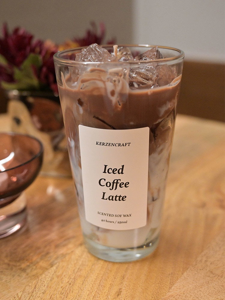Handgemaakte geurkaars in een glas, geïnspireerd op een iced coffee latte en afgewerkt met decoratieve ijsblokjes.