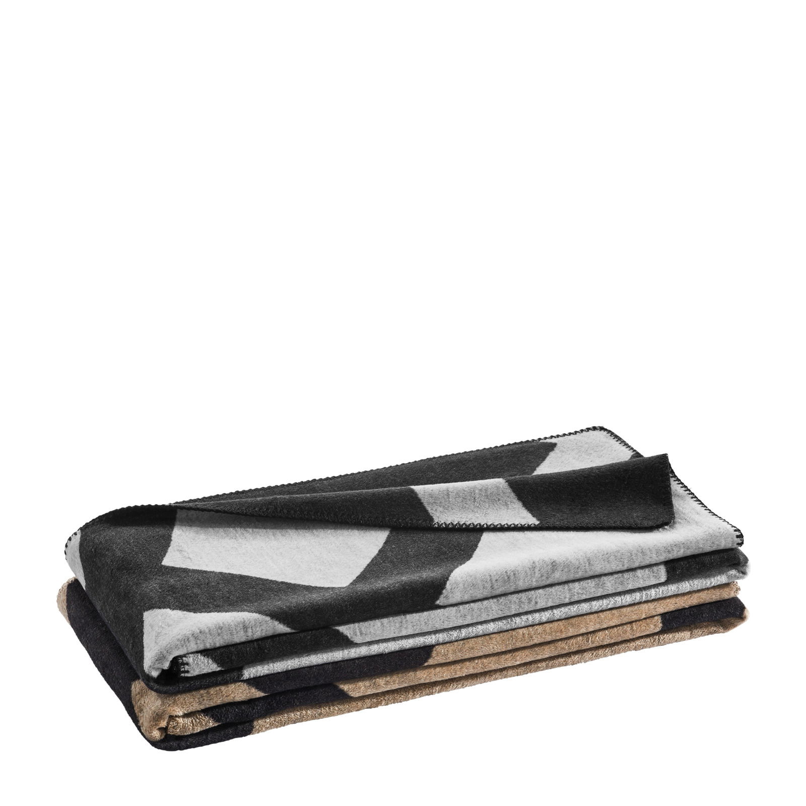 Gestapelte Wohndecke mit geometrischem Muster in Schwarz, Weiß und Braun, seitliche Perspektive