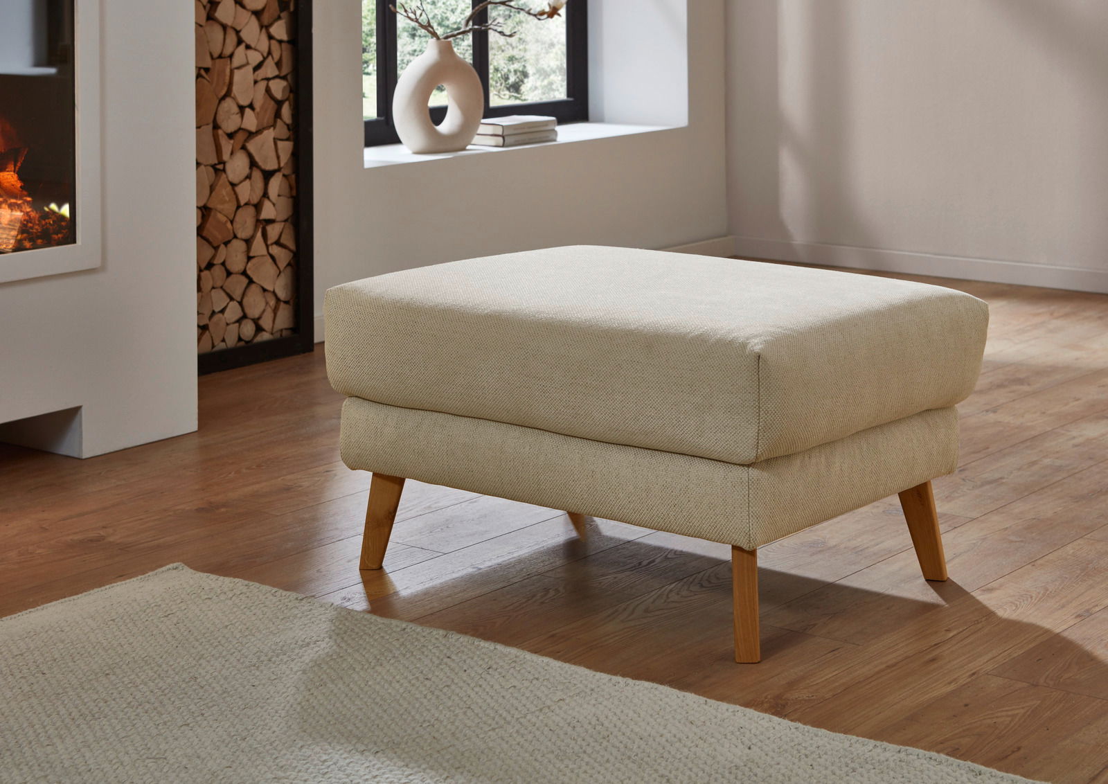 Beiger Hocker XL mit Holzbeinen in einem modernen Wohnzimmer, seitliche Perspektive