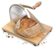 Brotschneidemaschine in Taupe mit Holzgriff, seitliche Perspektive, schneidet ein frisches Brot auf einem Holzbrett.