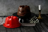 Zwei Silikon-Gugelhupfformen in Rot und Braun, auf einem dunklen Holztisch mit Blumen und Kerzenständer, aus seitlicher Perspektive fotografiert.