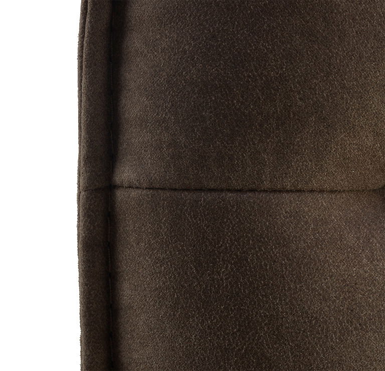 Nahaufnahme einer braunen, gepolsterten Bank mit weicher Textur, seitliche Perspektive
