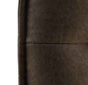 Nahaufnahme einer braunen, gepolsterten Bank mit weicher Textur, seitliche Perspektive