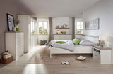 Helles Schlafzimmer mit einem 5-türigen Drehtürenschrank, Bett und Kommode in Holzoptik, seitliche Perspektive.