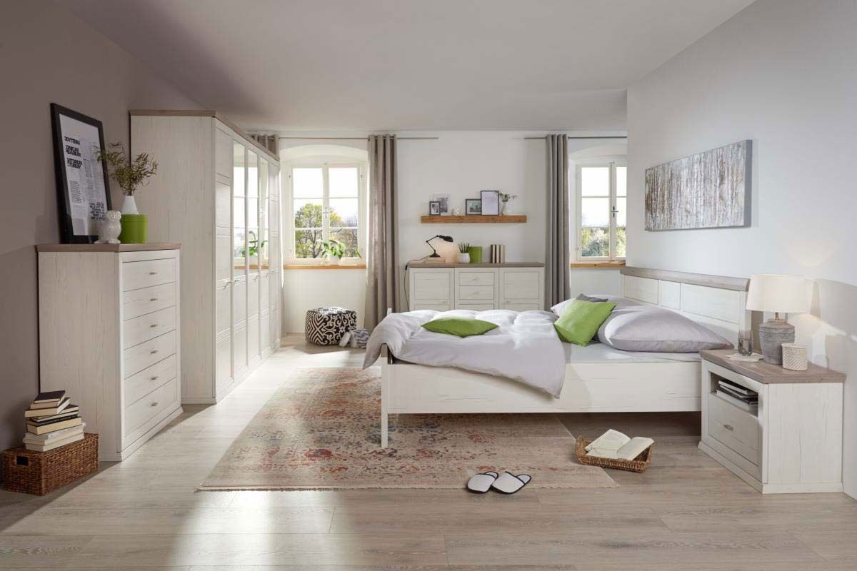 Helles Schlafzimmer mit einem 5-türigen Drehtürenschrank, Bett und Kommode in Holzoptik, seitliche Perspektive.