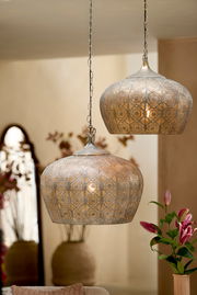 Zwei orientalische Hängeleuchten aus Metall mit filigranem Muster, von der Seite betrachtet, in einem stilvoll dekorierten Raum.