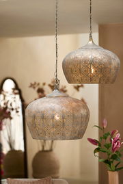 Zwei orientalische Hängeleuchten aus Metall mit filigranem Muster, von der Seite betrachtet, in einem stilvoll dekorierten Raum.