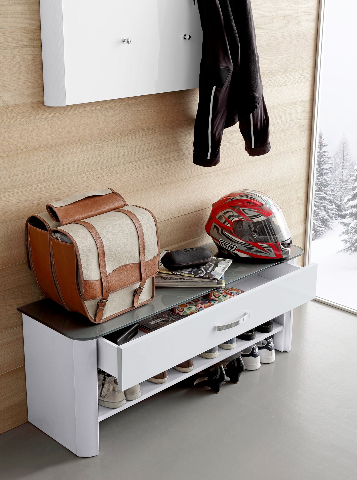 Weiße Bank mit Schublade und Schuhablage, darauf ein Helm und eine Tasche, seitliche Perspektive