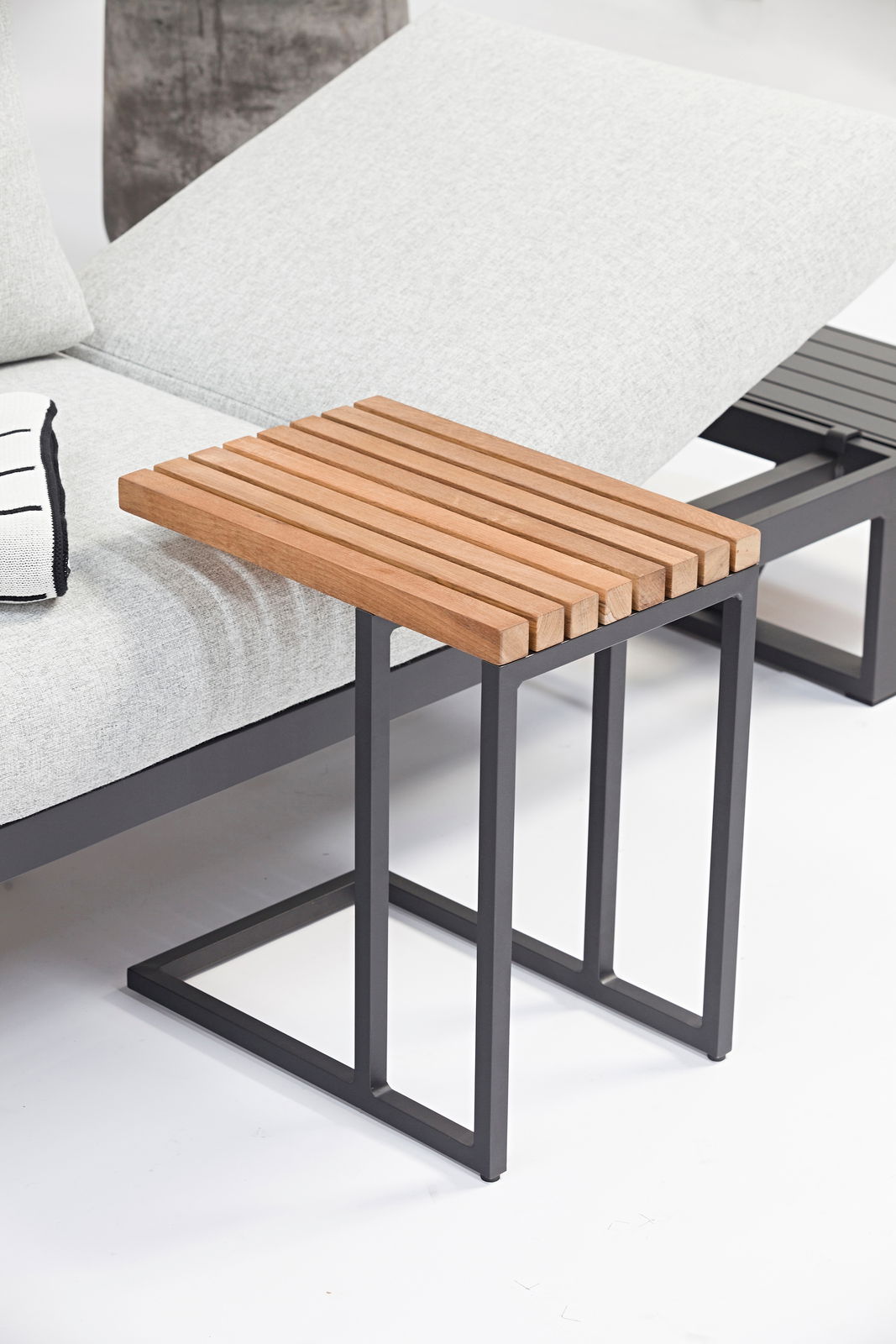 Moderner Beistelltisch mit Holzlatten-Oberfläche und schwarzem Metallgestell, seitliche Perspektive.