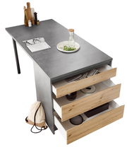 Kücheninsel mit grauer Arbeitsplatte, drei offenen Holzschubladen und Dekorationen aus der Vogelperspektive