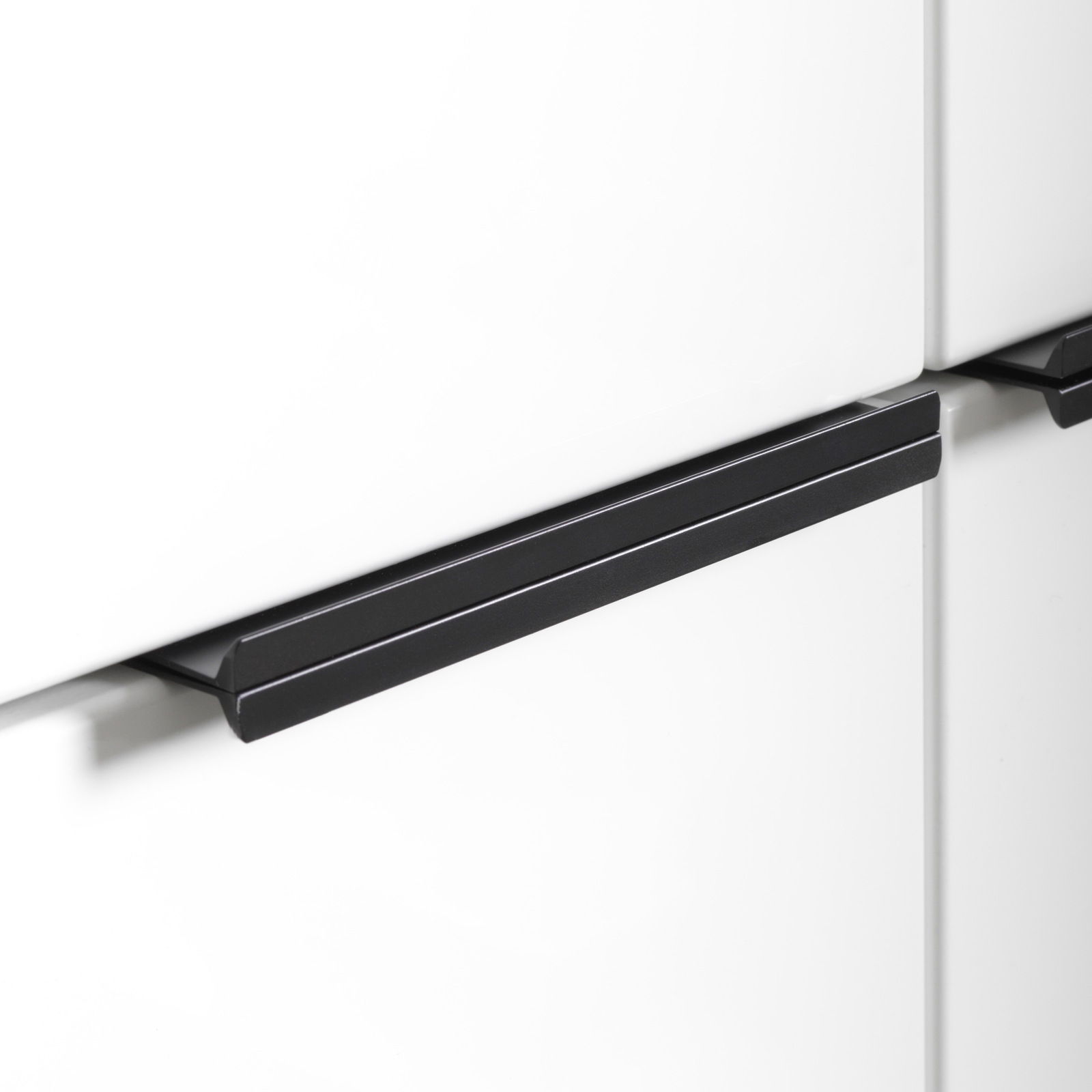 Nahaufnahme eines weißen Hochschranks mit schwarzem Griff, seitliche Perspektive