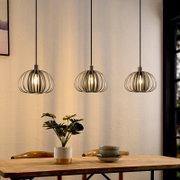 Drie moderne hanglampen met een metalen kooivormig ontwerp boven een eettafel, gezien vanaf de zijkant.