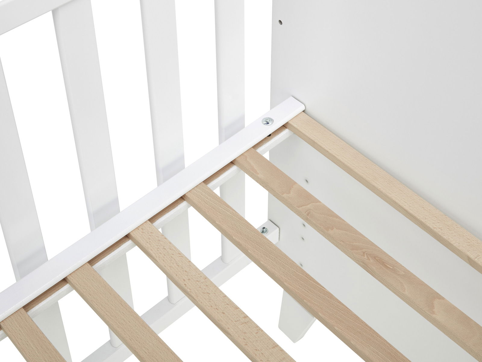 Nahaufnahme eines Babybetts mit weißen Gitterstäben und einem Lattenrost aus hellem Holz, von oben betrachtet.