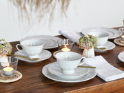 Elegantes Kaffeeservice 18-tlg auf einem gedeckten Tisch, seitliche Perspektive mit Kerzen und Blumenarrangement.