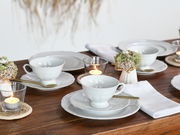 Elegantes Kaffeeservice 18-tlg auf einem gedeckten Tisch, seitliche Perspektive mit Kerzen und Blumenarrangement.