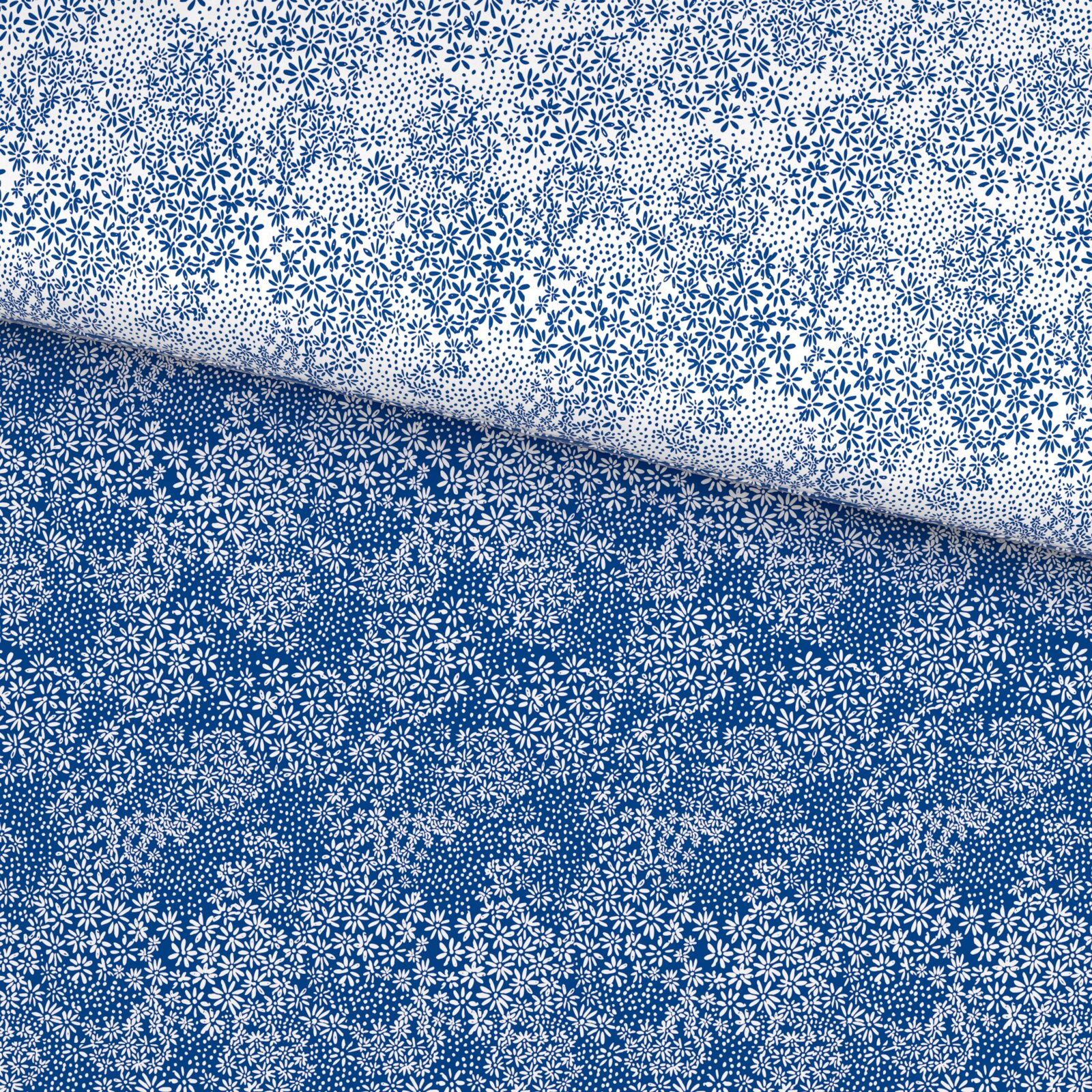 Nahaufnahme von blau-weiß gemusterter Bettwäsche mit kleinen Blumen und Punkten, schräg von oben fotografiert
