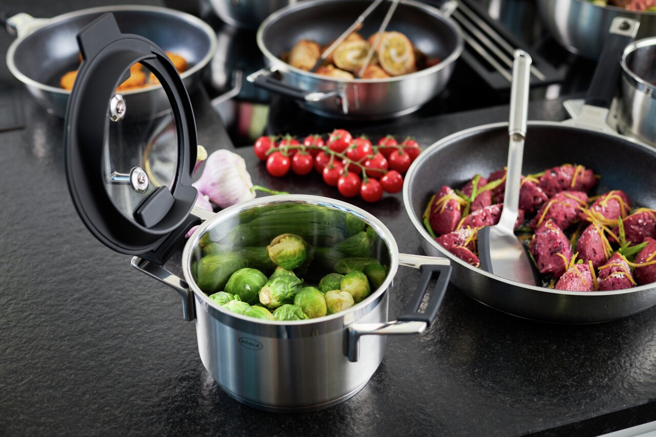 SILENCE PRO-pannenset van roestvrij staal met open deksel, gevuld met spruitjes, op een aanrechtblad. Aanzicht van bovenaf.