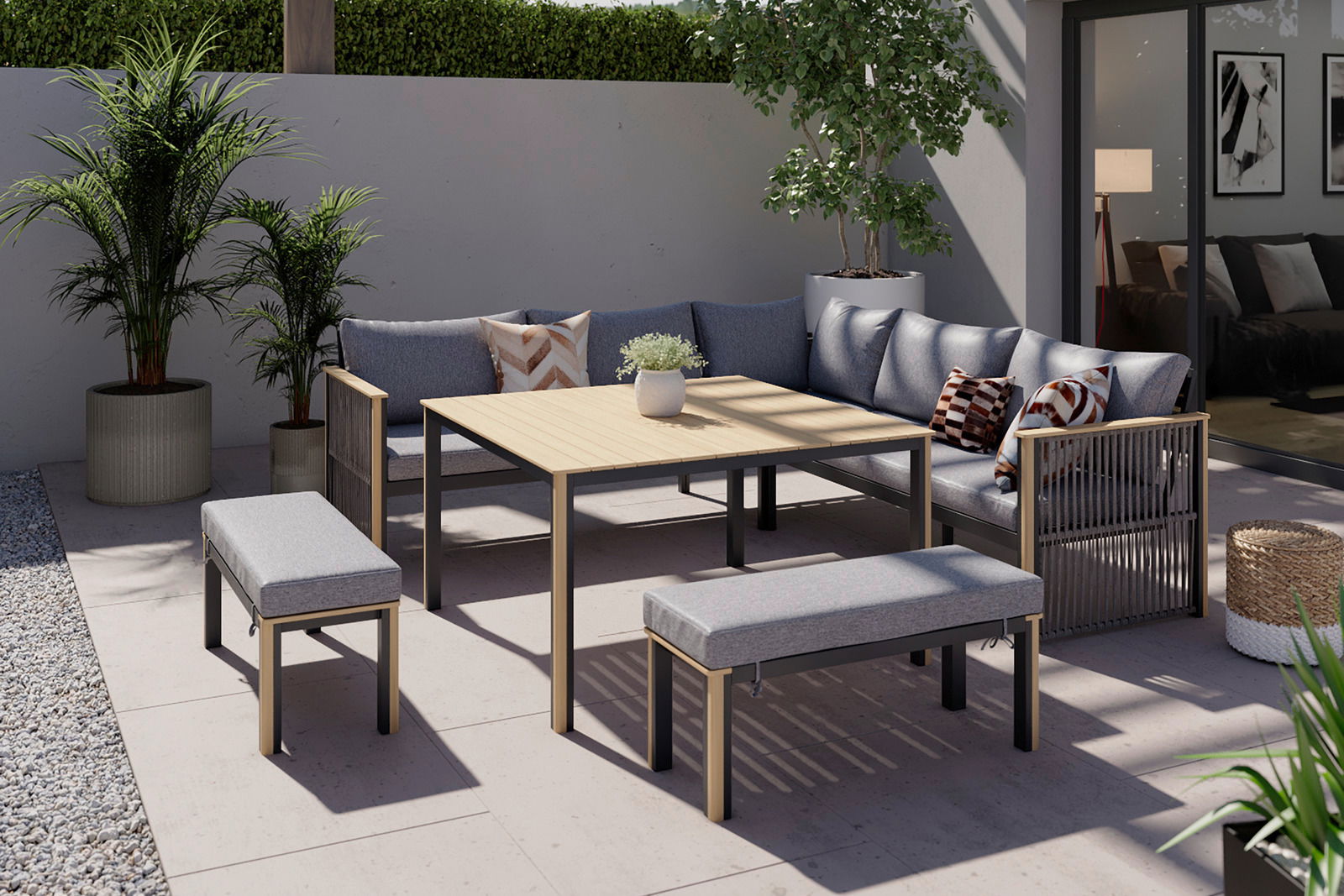 Lounge-Set auf einer Terrasse mit grauen Sofas, Holztisch und Bänken, umgeben von Pflanzen, aus der Vogelperspektive betrachtet.