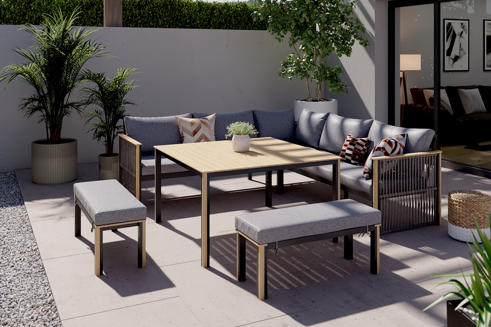 Lounge-Set auf einer Terrasse mit grauen Sofas, Holztisch und Bänken, umgeben von Pflanzen, aus der Vogelperspektive betrachtet.