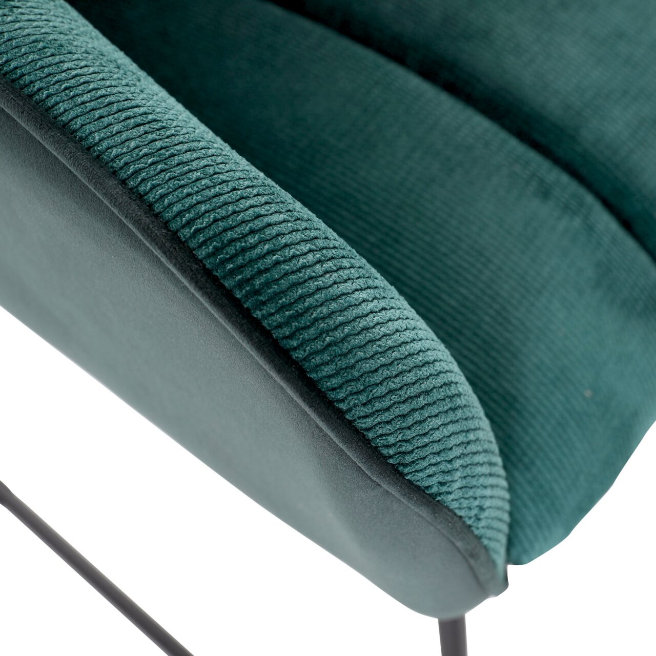 Nahaufnahme eines grünen Armlehnstuhls mit geripptem Stoffbezug und schwarzem Metallgestell.
