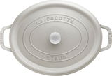 Obere Perspektive auf einen ovalen, weißen Bräter Cocotte 33cm mit der Aufschrift 'La Cocotte' und 'Staub'.