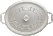 Obere Perspektive auf einen ovalen, weißen Bräter Cocotte 33cm mit der Aufschrift 'La Cocotte' und 'Staub'.
