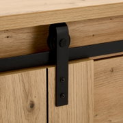 Close-up van een houten ladekast met een zwart metalen schuifmechanisme, gezien vanaf de zijkant