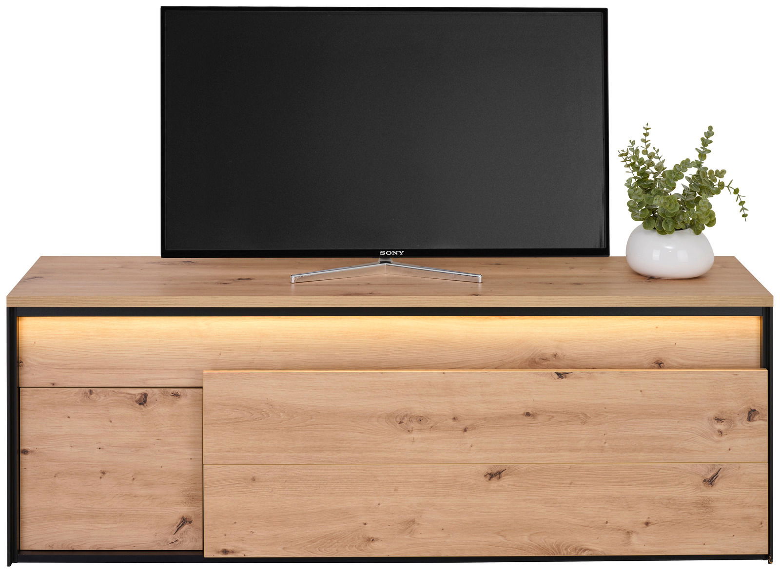 TV-Lowboard aus Holz mit LED-Beleuchtung, darauf ein Fernseher und eine Pflanze, frontale Ansicht