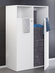 Weißer Badezimmer-Wäscheschrank mit geöffneten Türen und integriertem Wäschekorb in dunkelgrauer Stoffoptik, Handtücher hängen an den Fronten, schräg von vorn/rechts aufgenommen.