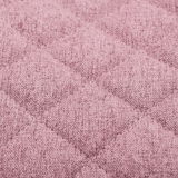 Nahaufnahme eines rosa gepolsterten Stoffes mit gestepptem Rautenmuster, perspektivisch von oben betrachtet.