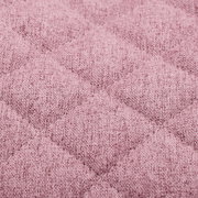 Nahaufnahme eines rosa gepolsterten Stoffes mit gestepptem Rautenmuster, perspektivisch von oben betrachtet.
