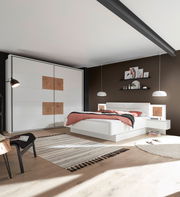 Moderne Schlafzimmeransicht mit weißem Schwebetürenschrank und Bettanlage, seitliche Perspektive