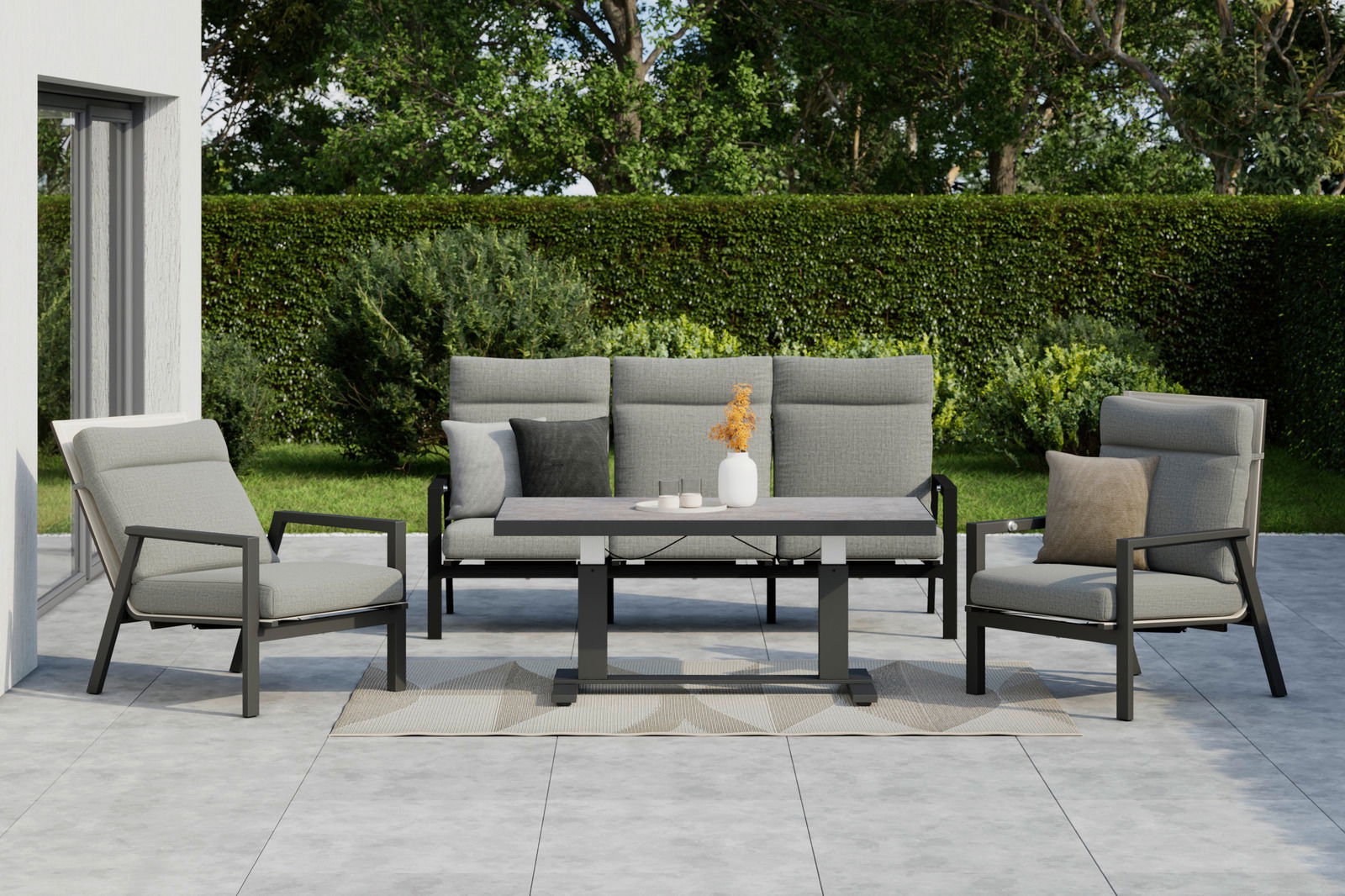 Gartenmöbel-Set mit zwei Sesseln, einer Bank und einem Tisch auf einer Terrasse, umgeben von grüner Hecke und Bäumen, aus der Frontperspektive.