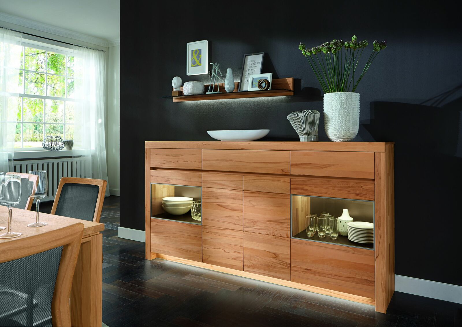 Hochwertiges Highboard aus Holz mit Glaseinsätzen, dekoriert mit Geschirr und Vasen, seitliche Perspektive