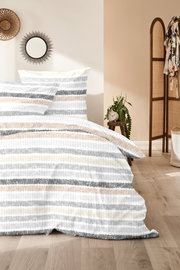 Bettwäsche-Set mit Streifenmuster in Grau, Beige und Weiß, auf einem Bett in einem gemütlichen Schlafzimmer mit Holzboden und Dekorationen, aus der Perspektive von vorne.
