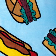Buntes Velourstuch mit Hotdog-Motiv auf hellblauem Hintergrund, aus der Vogelperspektive fotografiert.